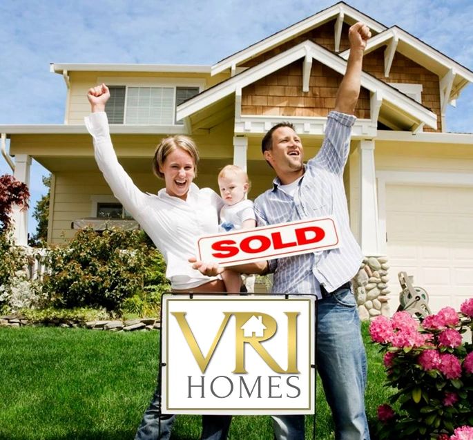Family with SOLD VRI Homes sign